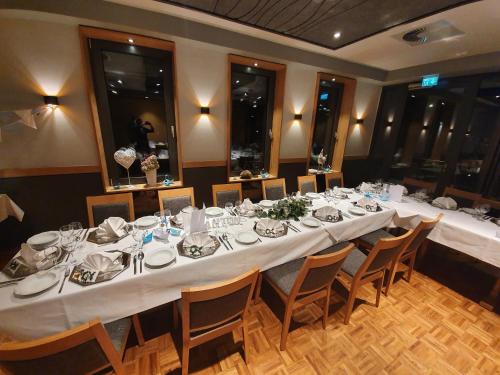a long table in a room with tables and chairs at Hotel Kiekenstein in Stahle