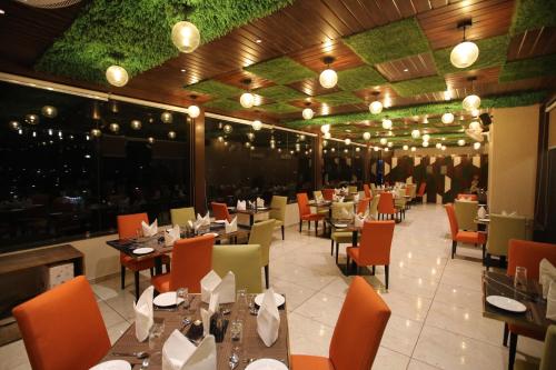a dining room with tables and chairs and lights at Hotel The Grand Chittor, Chittorgarh in Chittaurgarh