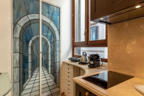 a kitchen with a painting of a hallway at Piazza di Spagna Elegant Apartment in Rome