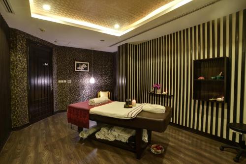 a bedroom with a bed in a room with striped walls at Pearl Continental Hotel, Lahore in Lahore