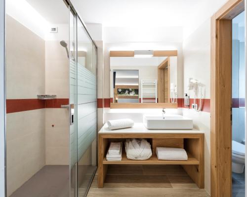 a bathroom with a sink and a shower at Family Hotel Serena in Andalo