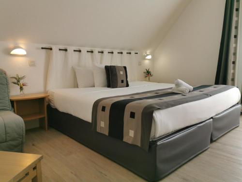 a bedroom with a large bed in a room at Logis Le Gavrinis in Baden