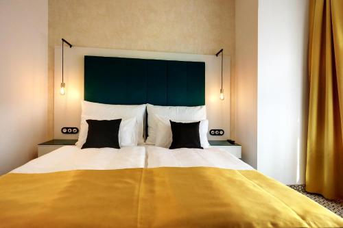 a bedroom with a large bed with a green headboard at Art Deco WOLKER by ASTORIA Hotel & Medical Spa in Karlovy Vary