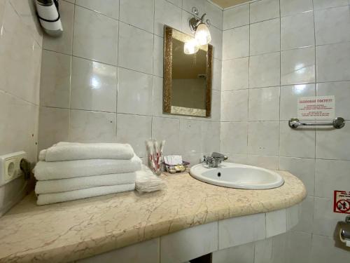 y baño con lavabo y toallas en la encimera. en Old City Apartment, en Odessa