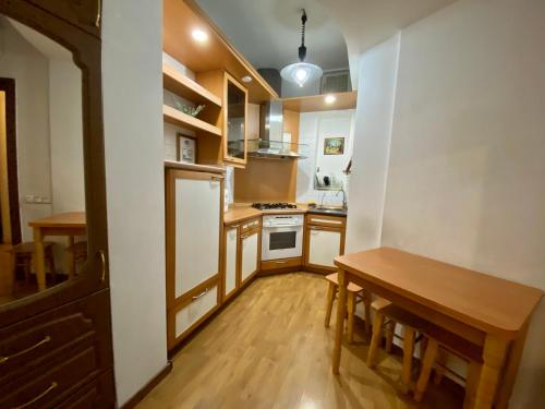 cocina pequeña con mesa de madera y suelo de madera en Old City Apartment, en Odessa