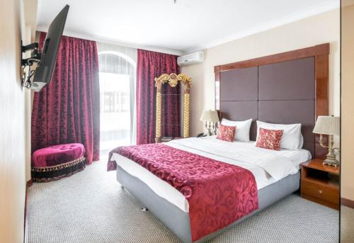 1 dormitorio con 1 cama grande con manta roja en Salut New Moscow Hotel, en Vnukovo