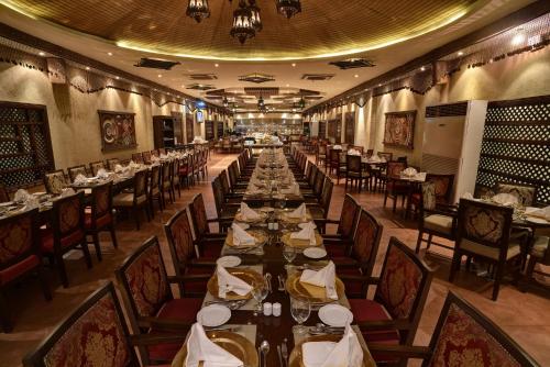a long dining room with long tables and chairs at Pearl Continental Hotel, Lahore in Lahore