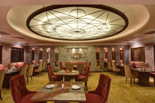 a restaurant with tables and chairs and a large ceiling at Pearl Continental Hotel, Lahore in Lahore