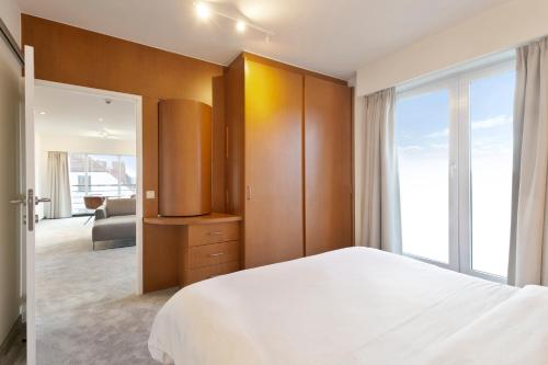 a bedroom with a white bed and a large window at Verac Flats in Zaventem