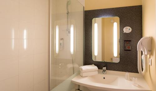 y baño con lavabo y ducha con espejo. en ibis Grenoble Centre Bastille, en Grenoble