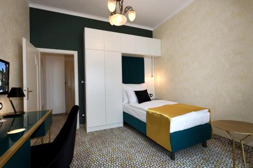 a hotel room with a bed and a table at Art Deco WOLKER by ASTORIA Hotel & Medical Spa in Karlovy Vary