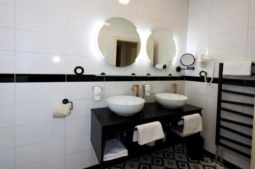 a bathroom with two sinks and a mirror at Art Deco WOLKER by ASTORIA Hotel & Medical Spa in Karlovy Vary