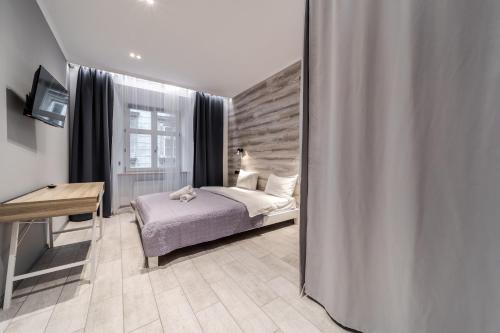 - une chambre avec un lit, un bureau et un miroir dans l'établissement Staroevreyska Apartment A, à Lviv