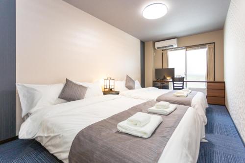 una camera d'albergo con due letti e asciugamani di SlowTime Hotel Kyoto a Kyoto