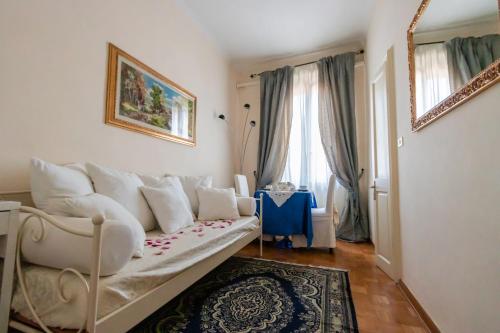 uma sala de estar com um sofá branco e uma janela em B&B Le Campane em Ferrara