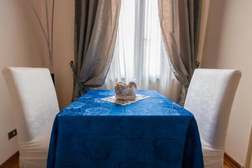 a table with a blue table cloth and two chairs at B&B Le Campane in Ferrara