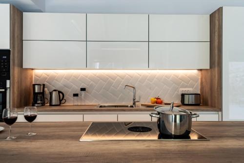 a kitchen with a pot and two glasses of wine at Swedish-Style Villa Salz in Fiskardho