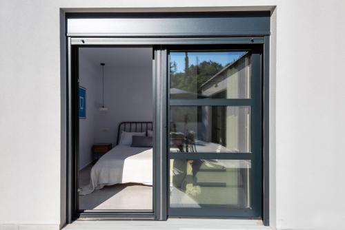 a sliding glass door leading to a bedroom at Swedish-Style Villa Salz in Fiskardho