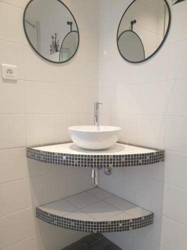 a bathroom with a sink and two mirrors on the wall at Residence Mare e Monte in Favone