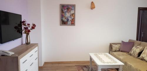 a living room with a couch and a table at Aparthotel Olympus Plaza - SPA & Indoor Pool in Kranevo