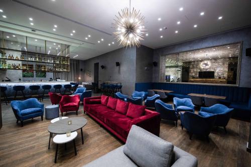 a restaurant with a red couch and blue chairs at Hotel De Ville in Beirut