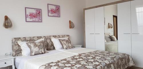 a white bedroom with a bed and a cabinet at Aparthotel Olympus Plaza - SPA & Indoor Pool in Kranevo