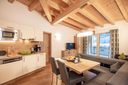 cocina y sala de estar con mesa y sofá en Apart Auszeit en Sölden