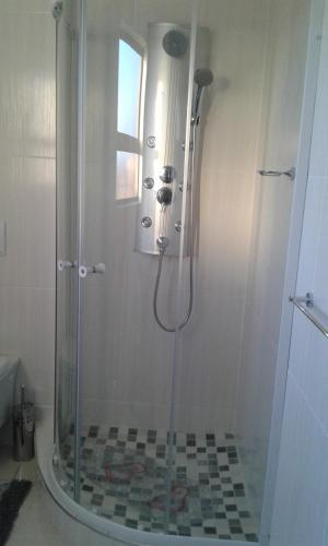 y baño con ducha y puerta de cristal. en @Home BnB en Maseru