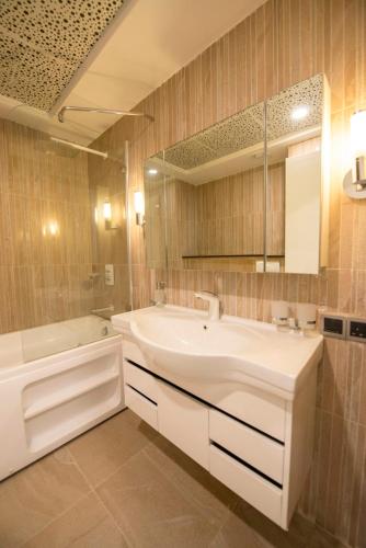 a bathroom with a large white tub and a sink at Centaurus Hotel Suites in Islamabad