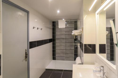 a white bathroom with a shower and a sink at Hôtel Spunta Di Mare in Ajaccio