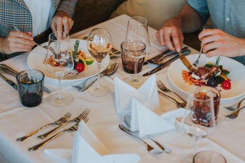 a group of people sitting around a table with plates of food at Ortner's Resort in Bad Füssing