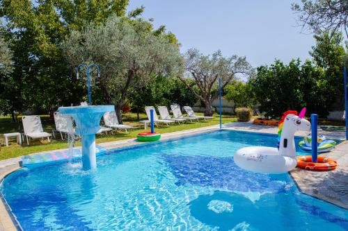 een zwembad met een waterpark met een fontein bij Sunset Apartments in Archangelos