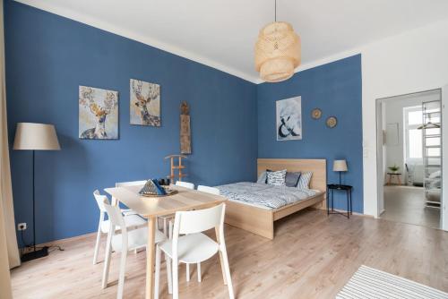 - une chambre avec des murs bleus, une table et un lit dans l'établissement Bright, Cozy & Quiet, à Vienne