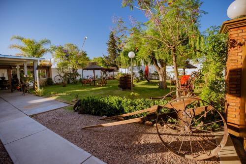 un jardín con un carro de madera en un patio en Abraham Complejo Turístico en San Rafael