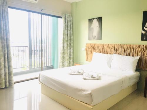 a bedroom with a bed and a large window at Tree Retro Hotel Chiang Mai in Chiang Mai
