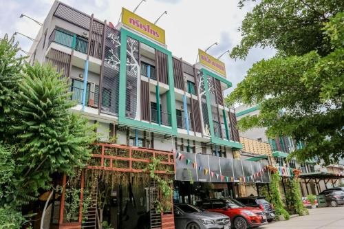 a building with cars parked in front of it at Tree Retro Hotel Chiang Mai in Chiang Mai