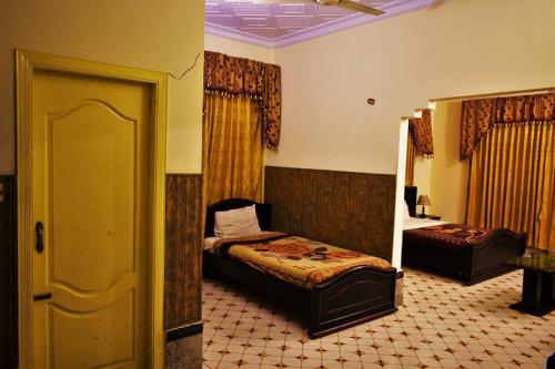 a bedroom with a bed and a chair in it at Suvastu Resort in Swat