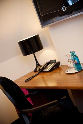 a desk with a lamp and a phone on it at Schloss zu Hopferau in Hopferau