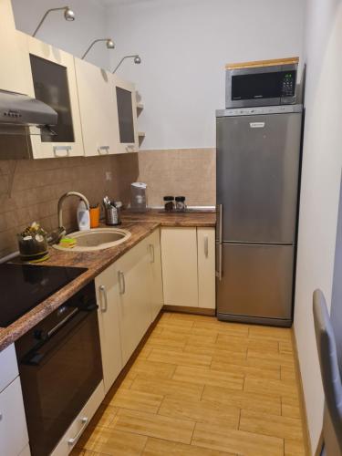 a kitchen with a stainless steel refrigerator and a sink at Apartament z garażem podziemnym - Augustowska in Olsztyn