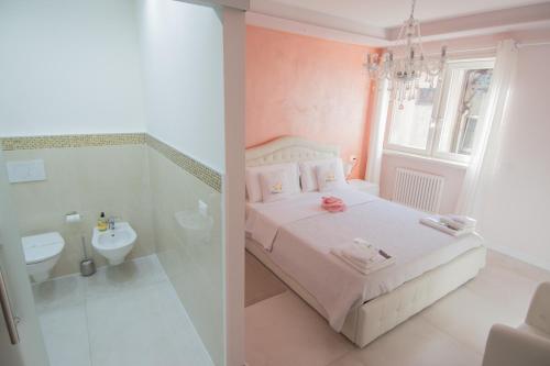 a bedroom with a bed and a bathroom with a sink at Klemi, rooms in old town Dolomia best home Check in automatico in Trento