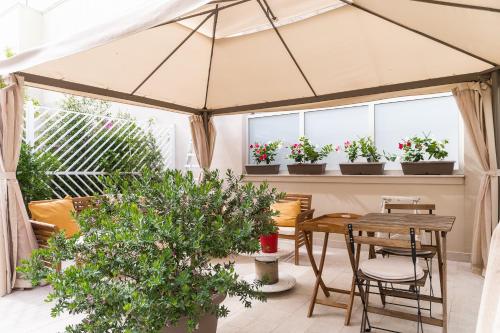 un patio con tavolo, sedie e piante di B&B Radici a Trani
