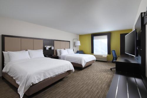 a hotel room with two beds and a flat screen tv at Holiday Inn Express Grand Rapids Southwest, an IHG Hotel in Grandville