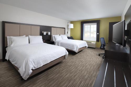 a hotel room with two beds and a flat screen tv at Holiday Inn Express Grand Rapids Southwest by IHG in Grandville