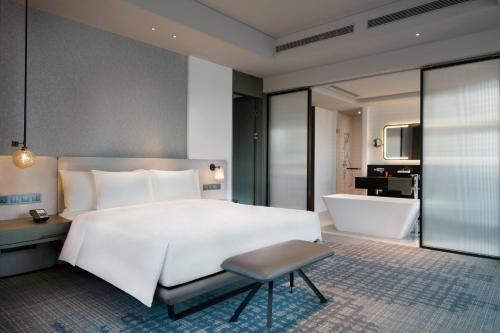 a bedroom with a large bed and a bath tub at Crowne Plaza Shenzhen World Exhibition and Convention Center by IHG in Shenzhen