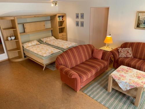 un salon avec un canapé et un lit dans l'établissement Exklusive Lage - Wohnung mit schönem Garten - Hämmerle Yellow, à Constance