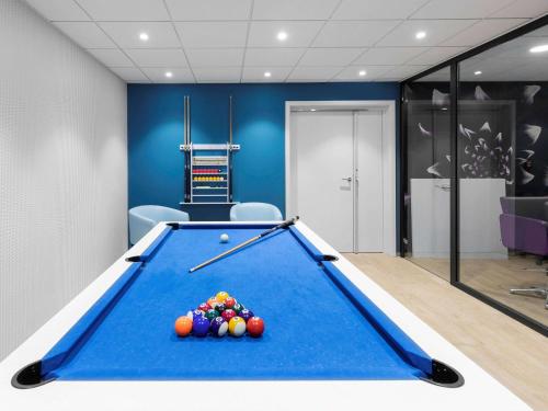 a pool table in a room with blue walls at Aparthotel Adagio Bâle Mulhouse Aeroport in Blotzheim