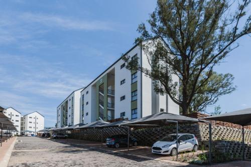 un bâtiment avec des voitures garées devant dans l'établissement Alimama Spaces: The Manson's Green Park, à Boksburg
