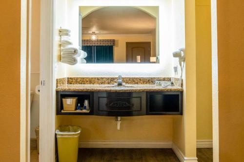 a bathroom with a sink and a mirror at Rodeway Inn & Suites Colton-Riverside in Colton