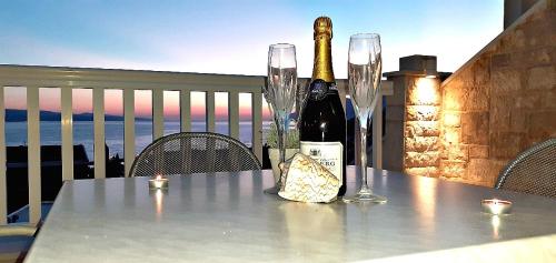 butelkę wina i dwa kieliszki na stole w obiekcie Apartments Villa Bonaca w Baskiej Vodzie