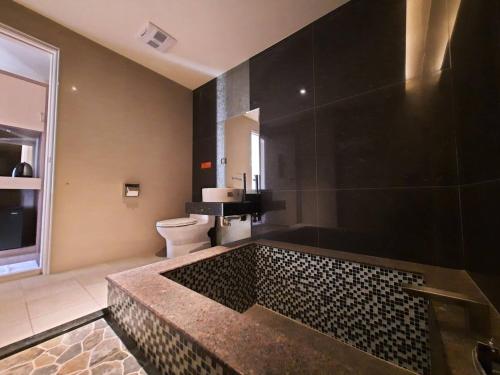 a bathroom with a large bath tub with a toilet at 埔里夏都華蔓山林日式會館 Puli Huaman Villa in Puli